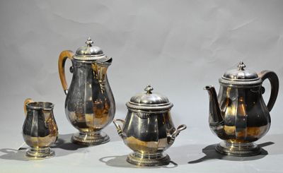 quatre théières en argent et deux tasses en argent posées sur une table