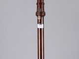 a tall wooden candle holder sitting on top of a glass table