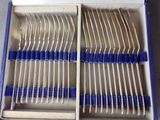 a box full of forks and spoons with blue handles