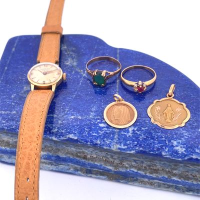 three rings, a watch, a bracelet, and a ring on a blue stone