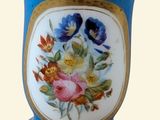 un vase bleu orné de fleurs peintes