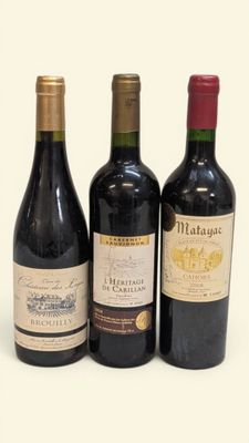 trois bouteilles de vin sont alignées sur une surface blanche