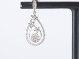 a close up of a pair of diamond earrings on a stand