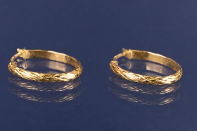 deux paires de boucles d'oreilles créoles en or sur un fond bleu