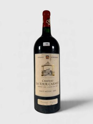 une bouteille de vin rouge posée sur une table blanche