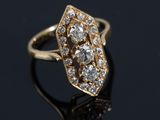gros plan d'une bague en or et diamants sur une surface noire