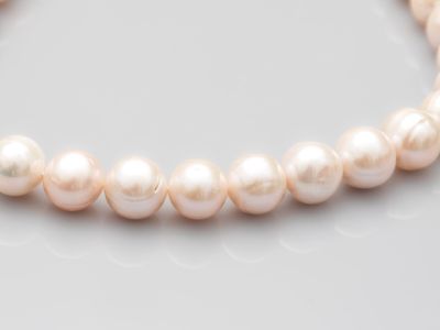 gros plan d'un collier de perles sur une surface blanche