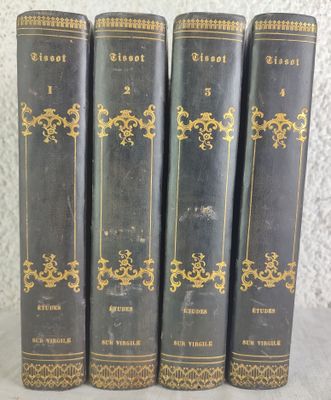 four old books are lined up on a white surface