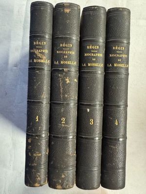 quatre vieux livres sont alignés sur une surface blanche
