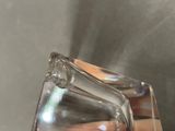 a person holding a clear glass object in their hand