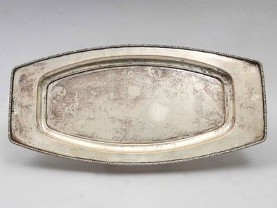 une assiette ancienne en argent, ornée d'un motif décoratif sur le bord