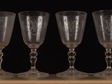 three wine glasses sitting on a table with a black background