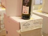 a bottle of wine sitting on top of boxes on a pallet