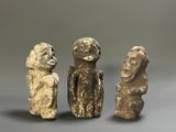 three stone figurines of a man and a woman
