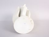 a white vase that has a small hole in the middle of it