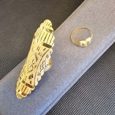 une bague en or et une bague en argent posées sur un tissu bleu