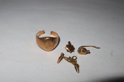 a gold ring and a pair of earrings on a table