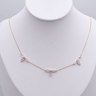 un mannequin blanc portant une chaîne en or et un collier blanc