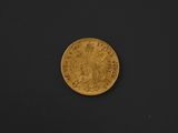 a close up of a gold coin on a black surface