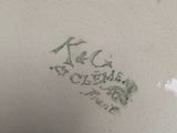 a close up of a white plate with a green design on it
