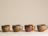 quatre tasses à café sont alignées sur une table