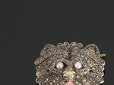 une image représentant une broche ornée de perles et d'une tête de chien