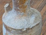 a cement vase sitting on a wooden floor next to a fire hydrant