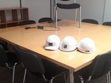 une table en bois sur laquelle sont posés des casques de chantier