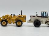 four toy construction vehicles that are lined up on a white surface