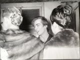 black and white photograph of a woman brushing her teeth in front of a mirror