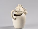 a white vase with three birds on top of it