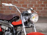 a red motorcycle parked in front of a brick wall