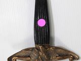 an image of a sword with a pink dot on it