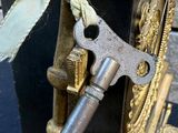 a small clock with a key attached to it ' s side