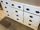 an image of a white dresser with black knobs in a room