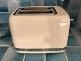 a toaster that is sitting on a tiled floor