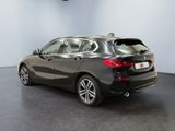 the back end of a black bmw car in a showroom