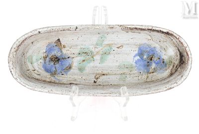 une assiette blanche décorée de fleurs bleues, posée sur un socle