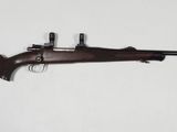 un fusil avec un canon en bois sur fond blanc