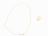 a gold necklace with a gold disc and a gold necklace with a gold disc