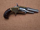 an old revolver with a wooden handle on a brown surface