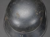 an old metal helmet sitting on top of a gray surface