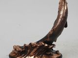 an image of a bronze statue of a whale on a black base