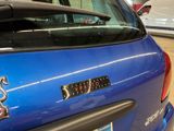 a blue car that has a sticker on the back of it