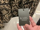the person is holding a black and white jacket with a name tag