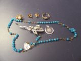 un collier de perles bleues orné d'un oiseau en argent
