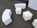 a group of white chairs and stools on the ground