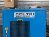 une photo d'un compresseur bleu posé sur une palette en bois