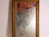 un miroir accroché au mur à côté d'un vase