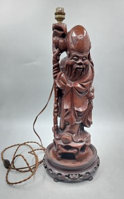 an image of a statue of a man holding a lamp on top of a table